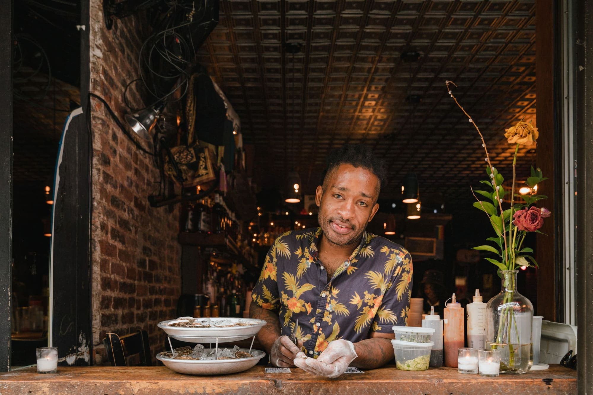 A smiling restaurant owner at the counter of a small restaurant